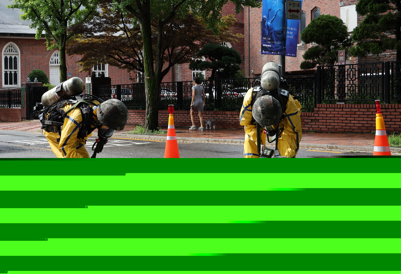 This photo shows soldiers on Wednesday morning handling waste contained in a balloon flying from North Korea near the Jeondong Theater in Jung-gu, central Seoul,. (Yonhap)
