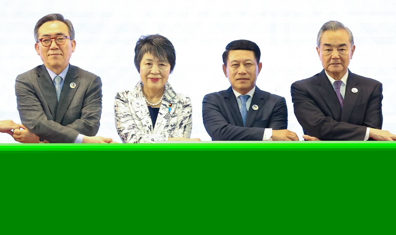 From left: Foreign Minister Cho Tae-yul, Japanese Foreign Minister Yoko Kamikawa, Laotian Foreign Minister Saleumxay Kommasith and Chinese Foreign Minister Wang Yi hold hands for a photo shoot as they attend a foreign ministerial meeting of the ASEAN Plus Three in Vientiane, Laos, on Saturday. (Yonhap)