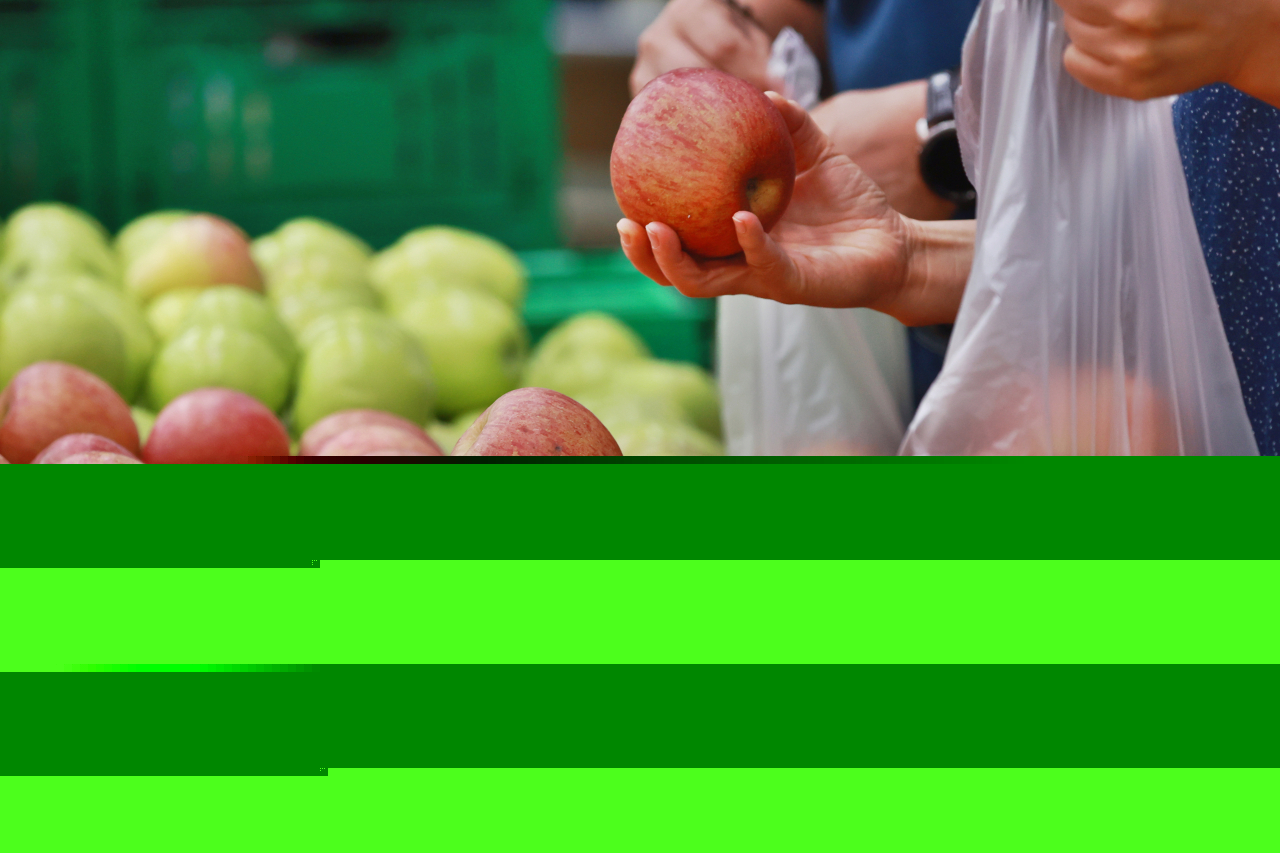 Shoppers bag apples at a supermarket in Seoul on Sunday. (Yonhap)