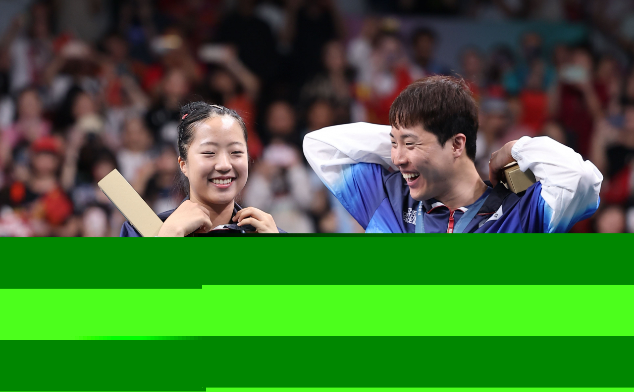 Shin Yu-bin (left) and Lim Jong-hoon of South Korea celebrate after winning the bronze medal in the mixed doubles table tennis event at the Paris Olympics at South Paris Arena 4 in Paris on Tuesday. (Yonhap)